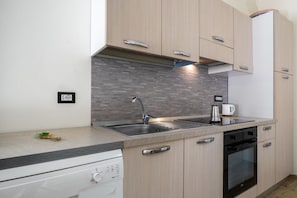 A modern kitchen with a dishwasher, oven, and a coffee maker on the countertop. - A cozy apartment of approximately 90 square meters, spread over two levels connected by stairs, accommodating up to 6 people.The property is located in Torre Faro, a charming seaside village about 15 km from Messina, where the Ionian and Tyrrhenian Seas  (Messina)