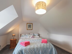 A bedroom with a bed, a nightstand, a lamp, a framed picture, and a ceiling light. - 3 Bruaich Cottages (Strathpeffer)
