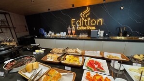 Buffetområde med forskellige spisemuligheder og skilt til kaffebar.
