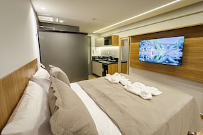 Une chambre d’hôtel équipée d’un lit, d’une télévision, d’une kitchenette et d’une salle de bain.