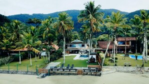 Un resort con varias construcciones, una piscina y palmeras.