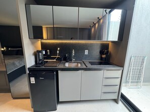 A compact kitchen with a built-in oven, a sink, and a compact refrigerator. - First floor apartment with terrace at Acqua Tambau AQTX5 (João Pessoa)