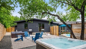 A backyard with a hot tub, outdoor furniture, and a wooden deck. - Wonderland Unit A · Sleeps 12, Hot Tub & BBQ (Austin)