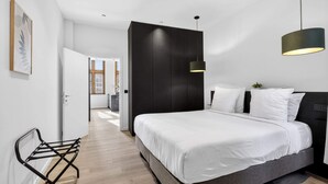 A modern bedroom with a large bed, a desk, and a chair. - Maison Grand-Place 2 (Brussels)