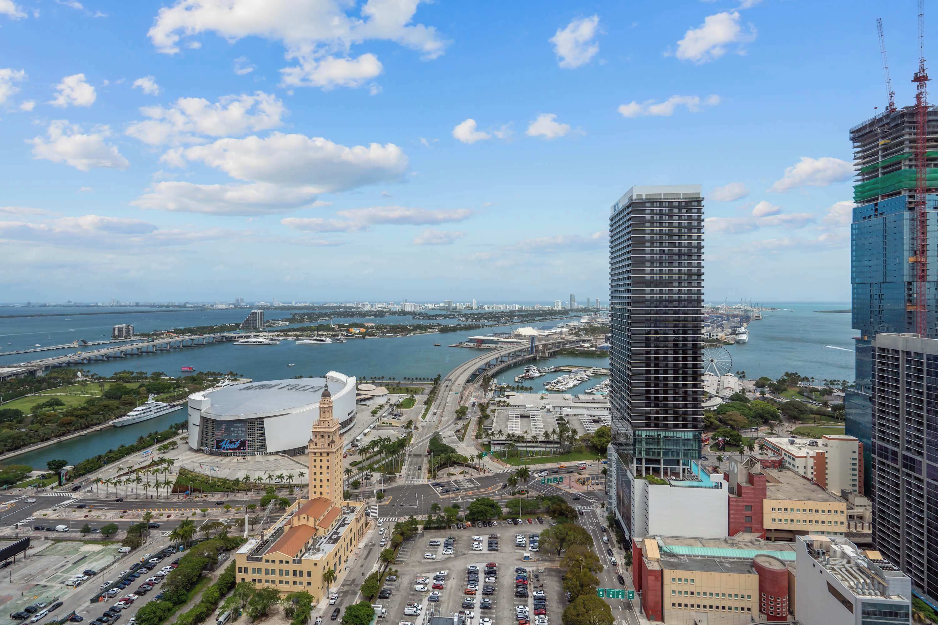 A cityscape with modern buildings, a marina, and a large curved road.