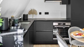 A modern kitchen with a built-in oven, a toaster, and a decorative plant.