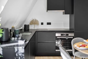 Eine moderne Küche mit Einbauofen, Toaster und einer Zierpflanze.