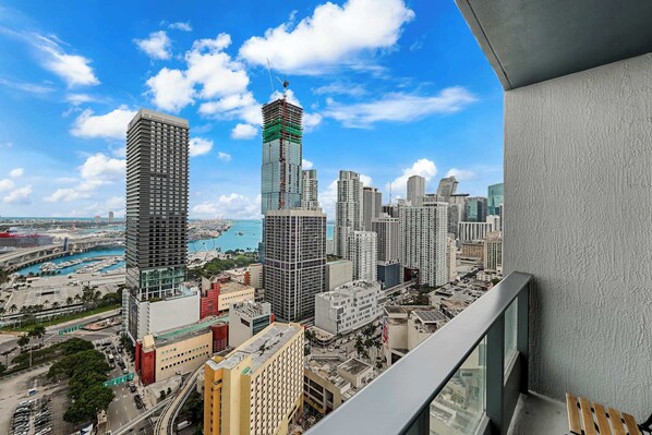 A high-rise building with a view of a cityscape, including other tall buildings and a body of water. - Sleek Studio | Pool / Cinema | FIFA Fan Fest Walk (Miami)