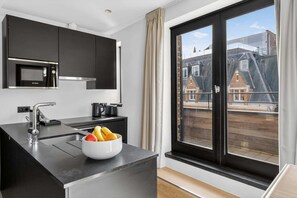 A modern kitchen with a Bosch microwave, a kettle, and a fruit bowl on the counter. - Maison Grand-Place F (Brussels)