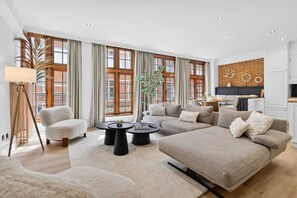 Ein geräumiges Wohnzimmer mit einer Sofagarnitur, einem Couchtisch und einer Stehlampe.