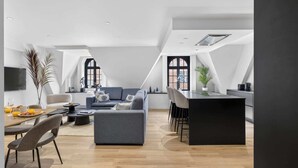 Un espace de vie moderne de style loft comprenant un coin repas, une cuisine et un espace détente.