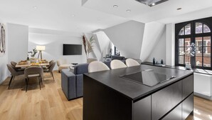 Une cuisine moderne dotée d’un îlot central, d’un coin repas avec une table et des chaises, et d’une grande fenêtre offrant une belle vue.
