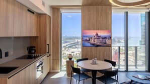 Eine moderne Küche mit großem Fenster, einem Essbereich mit Tisch und Stühlen sowie Blick auf die Stadt.
