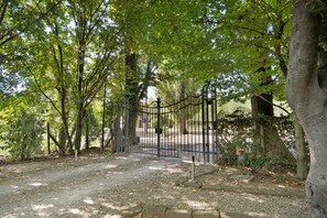 A gated entrance with a gravel path leading through a wooded area. - 'Grimilda' Apartment with Shared Pool, Wi-Fi and Air Conditioning (Piombino Dese)