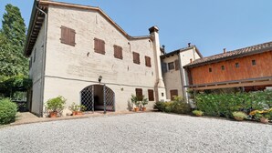 A building with a gravel driveway, a wooden door, and potted plants.