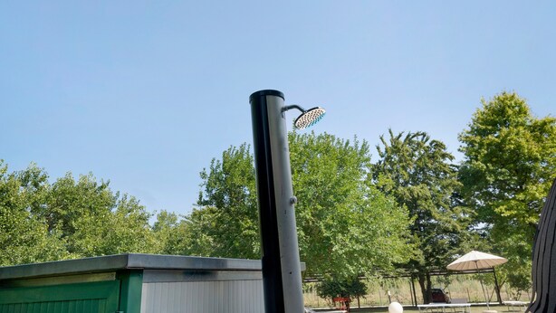 A clear sky with a metal pole and a shower head attached to it.