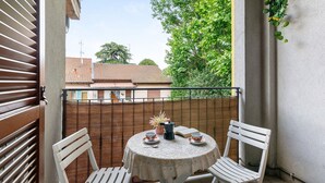 A balcony with a table, two chairs, a potted plant, and a book. - Holiday Home 'Dimora Chiaretta' with Balcony, Wi-Fi and Air Conditioning (Caronno Pertusella)