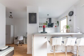 Eine moderne Küche mit einer zentralen Kochinsel, Barhocker und einem Essbereich.
