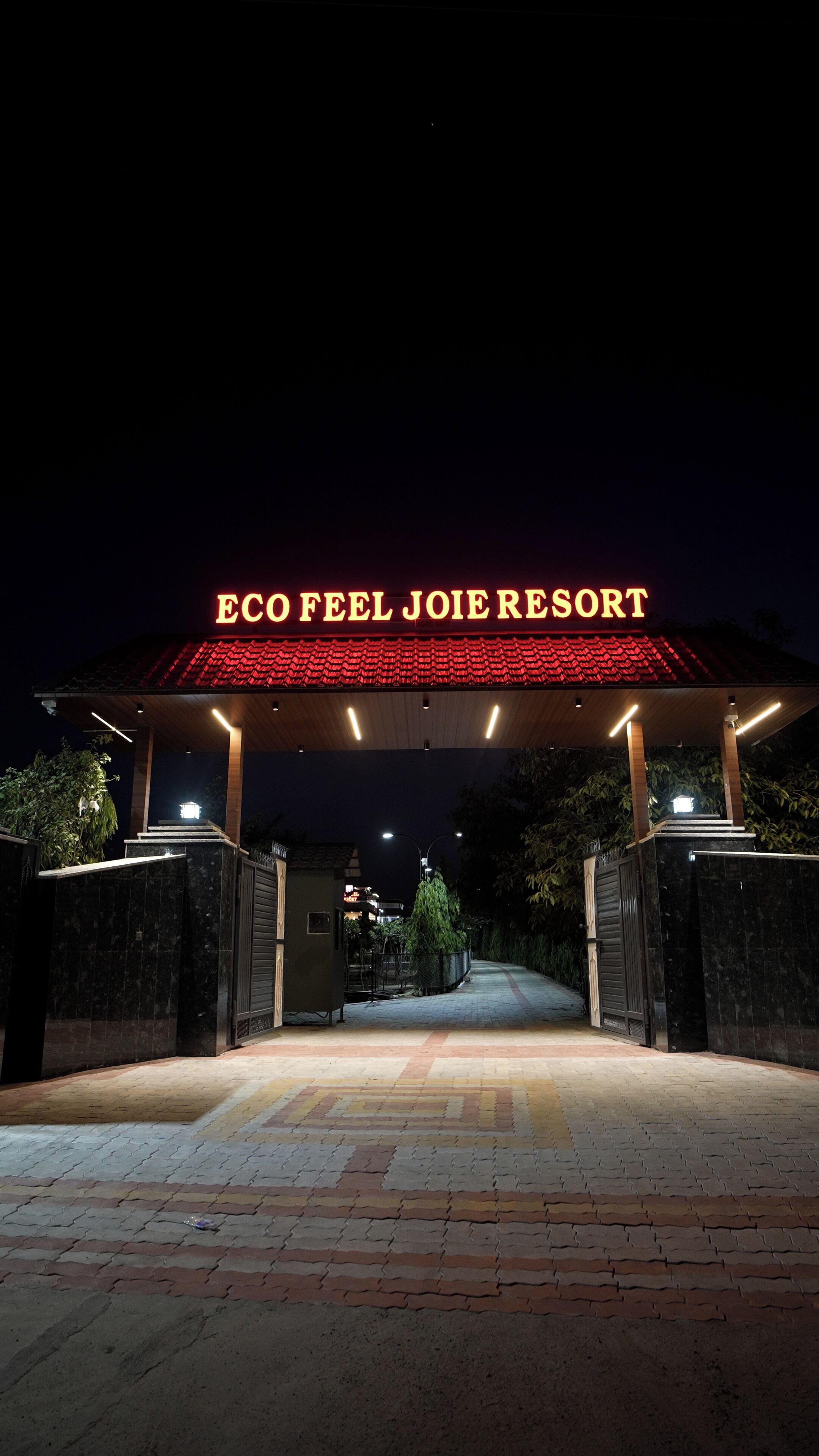 La entrada al Eco Feel Joie Resort, con techo de tejas rojas y un cartel arriba.