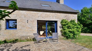 A stone building with a patio, two chairs, and a table. - Penty du Trehiat - À moins d'1 km de la plage (Sarzeau)