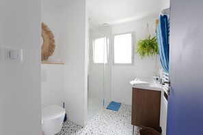 A bathroom with a toilet, shower, sink, and a potted plant. - El Nido - charmante maison de vacances (Les Sables d'Olonne)