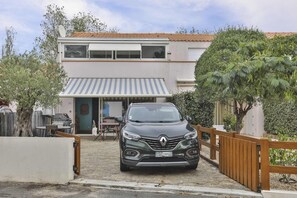 A two-story house with a car parked in front. - L'Océanide - dans une belle résidence avec piscine (Bretignolles-sur-Mer)