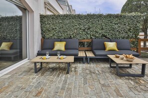 An outdoor seating area with two sofas, two tables, and a hedge wall. - L'Océanide - dans une belle résidence avec piscine (Bretignolles-sur-Mer)