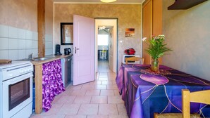 Une cuisine équipée d’une cuisinière, d’un évier et d’un coin repas avec une table.