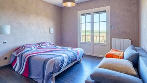 Une chambre à coucher avec un lit, un canapé, une fenêtre et un radiateur.
