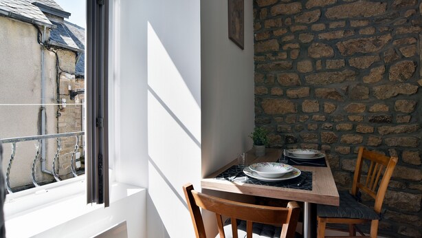 Zona pranzo con tavolo, sedie e vista dalla finestra.