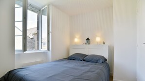 Una camera da letto con un letto, una finestra e due lampade a parete.