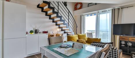 A modern apartment with a kitchen, dining area, and living space.