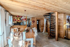 Un interior de madera con una mesa de comedor, sillas, una escalera y una decoración con forma de corazón.