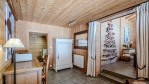 Ein Holzinnenraum mit einer Essecke, einem weißen Schrank und einem Weihnachtsbaum.