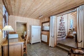 Un interior de madera con comedor, un armario blanco y un árbol de Navidad.
