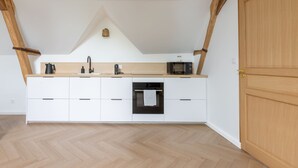 A kitchen with white cabinets, a microwave, a kettle, and a built-in oven. - Louisa - Entre Nature et Loisirs (Saint-Calais)