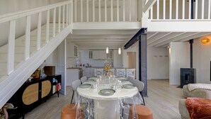 Ein Essbereich mit einem runden Tisch, Stühlen und einer Treppe.