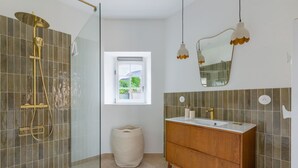 Un bagno con doccia, lavabo e una finestra vista.