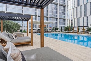 A rooftop pool area with lounge chairs and a pergola structure. - Luxe Urban Escape in Phoenix | Full kitchen | Workspace & Resort Amenities (Maricopa County)