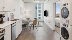 Een moderne keuken met een eethoek, inbouwapparatuur en een groot raam.