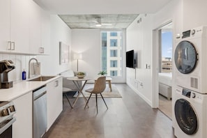 A modern kitchen with a dining area, built-in appliances, and a large window. - Urban Adventure Stay Phoenix | Gym & Central Location | Resort Pool (Maricopa County)