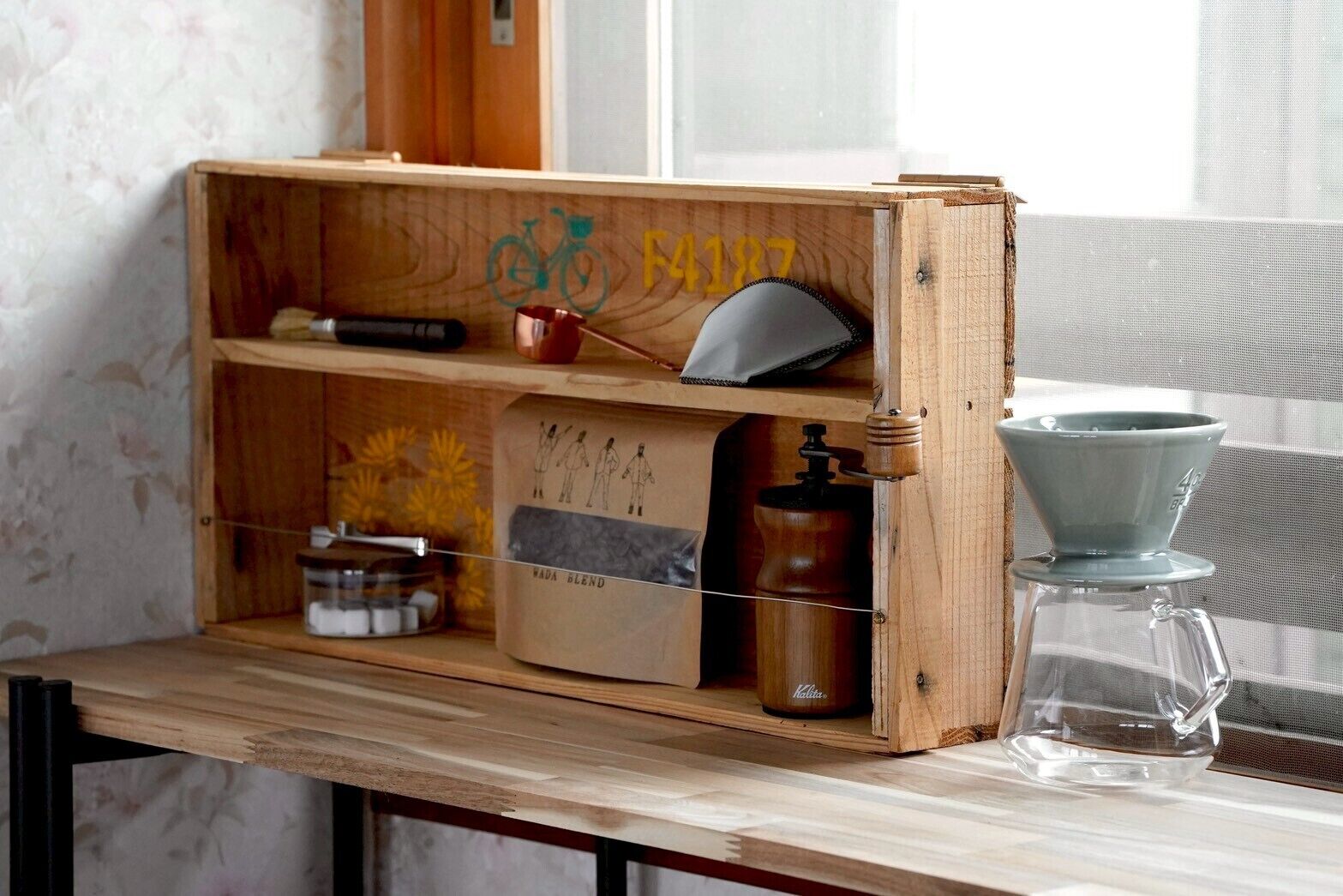 A wooden shelf with a bicycle symbol, a number 4187, and a coffee maker.