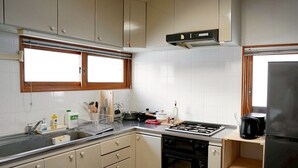 Une cuisine équipée d’une cuisinière, d’un four, d’un évier et de placards.