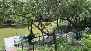 Eine Holzterrasse mit Steintreppen, die zu einem Steg über dem Wasser führen.