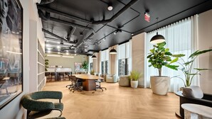 A modern office space with a large wooden table, comfortable seating, and large windows. - Stylish Studio Steps from Brightline & Downtown (Miami)