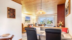 A dining area with a table, chairs, and a view of the outdoors. - Cozy Apartment with Private Sauna, Garden, and Sunny Terrace (Feldberg)
