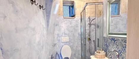 Une salle de bain équipée de toilettes, d’une douche et d’un lavabo.
