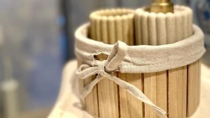 A wooden container with a fabric band and a gold-colored pump, likely for toiletries. - DIMORA DI LEO (Bisceglie)