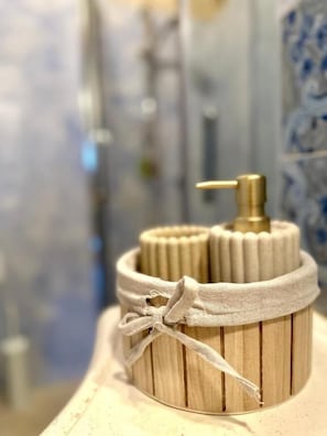 Un recipiente de madera con una cinta de tela y un dispensador dorado, probablemente para artículos de tocador.