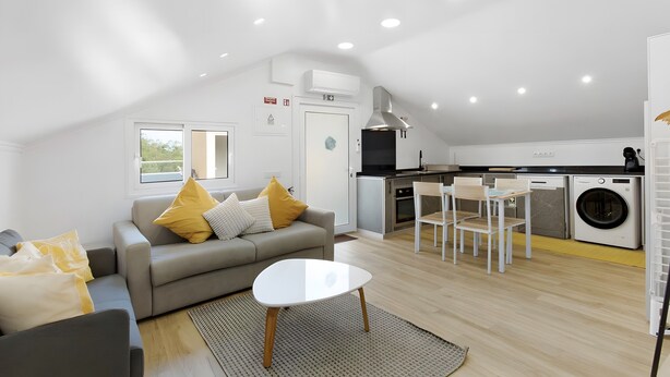 A modern apartment with a living area, kitchenette, and laundry facilities. - Holiday Home 'Palheiro Dis 3’as' with Sea View, Wi-Fi and Air Conditioning (Achadas da Cruz)